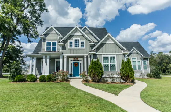 A large house with a blue door and a walkway leading to it.